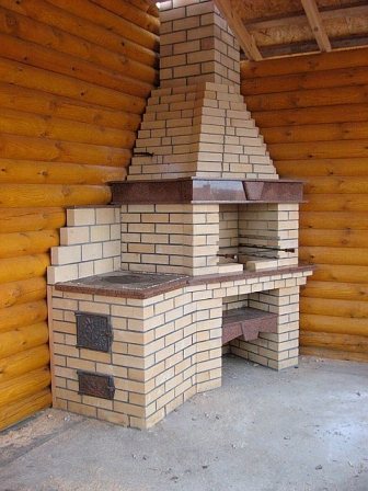 Photo of a fireplace stove with a barbecue in a bathhouse made of calibrated logs.
